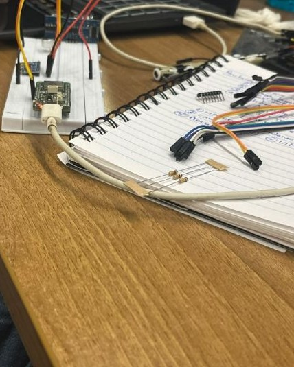 The ESP32-H2 board on a breadboard next to a notebook