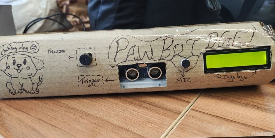 The PawBridge device: sensors, buzzer and LCD inside a hand-labelled cardboard box