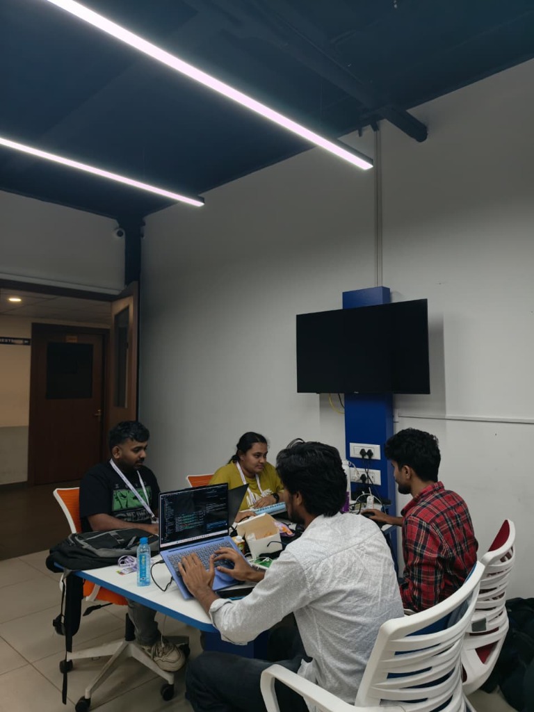 The team hacking through the night around the table in Kochi